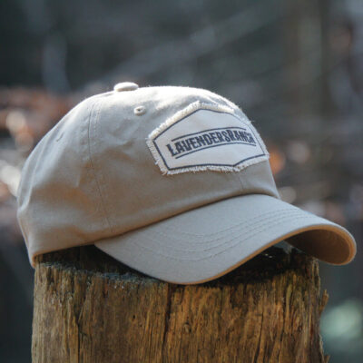 The Original Cap in Light Khaki on a tree stump.
