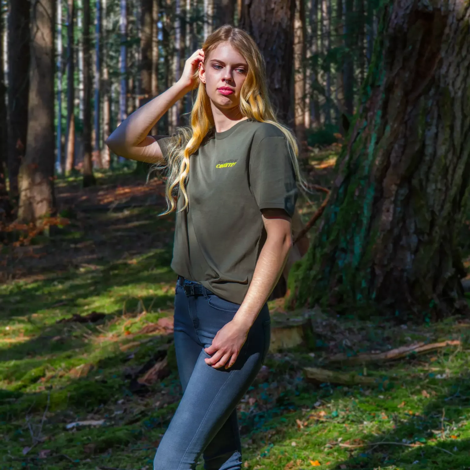 LavendersRanch T-Shirt khaki green with yellow “Powered by Country” chest print, modeled in a forest clearing.