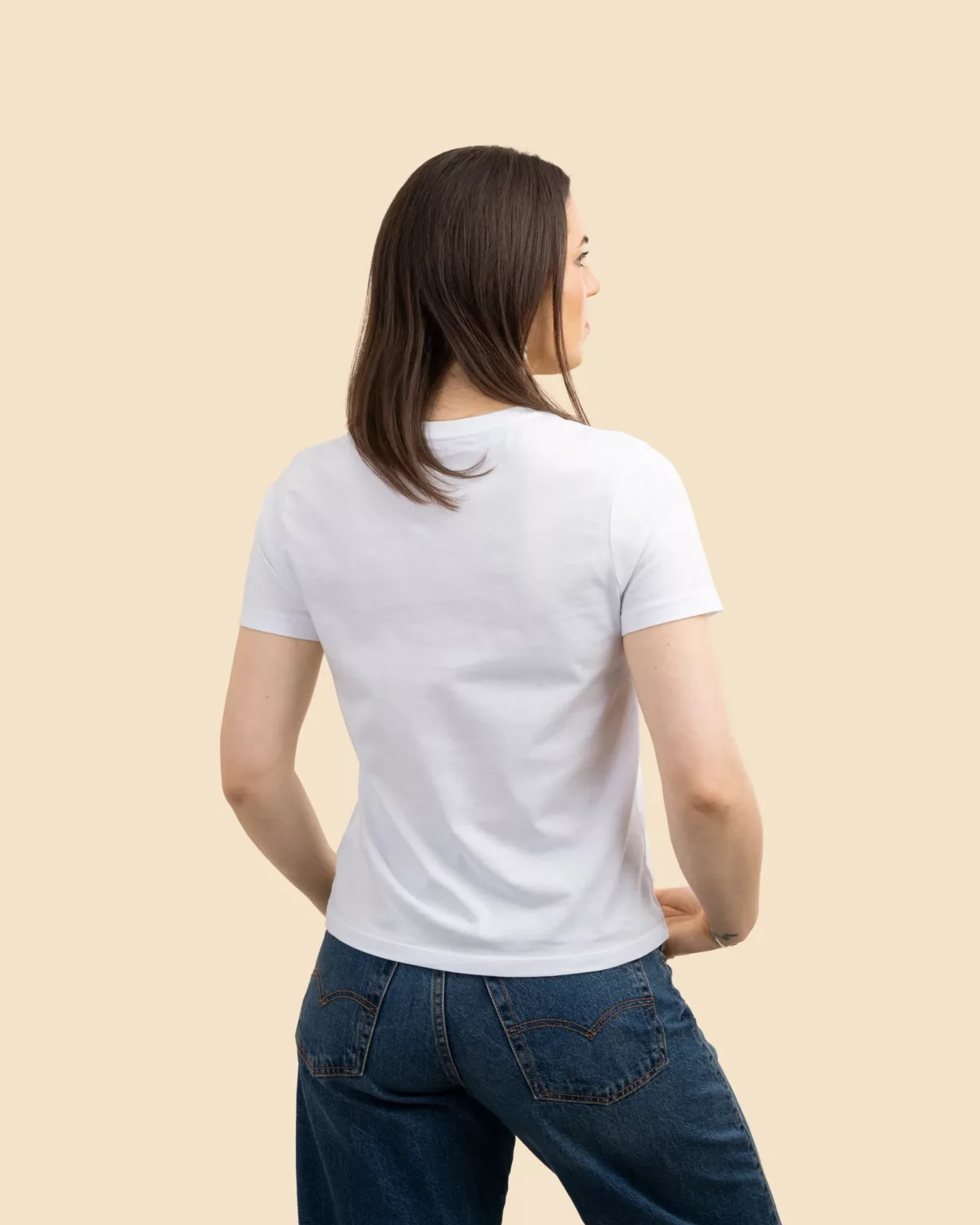 Back view of a woman wearing a white women’s fit T-shirt by LavendersRanch (LR), made from GOTS certified organic cotton, styled in clean western country fashion.