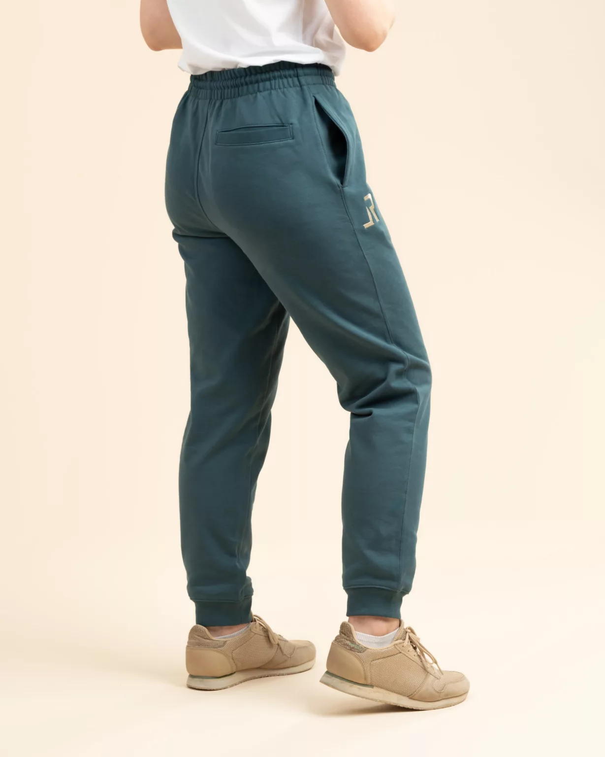 Back view of sustainable teal blue sweatpants with side pockets and embroidered logo by LavendersRanch (LR), perfect for casual outdoor lifestyle.