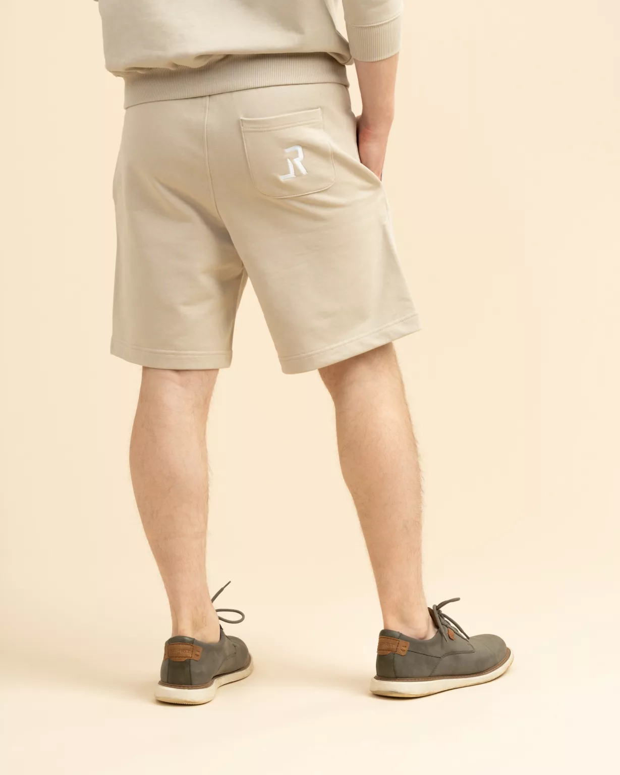 Back view of unisex beige desert shorts with embroidered LavendersRanch (LR) logo, made from sustainable organic cotton.