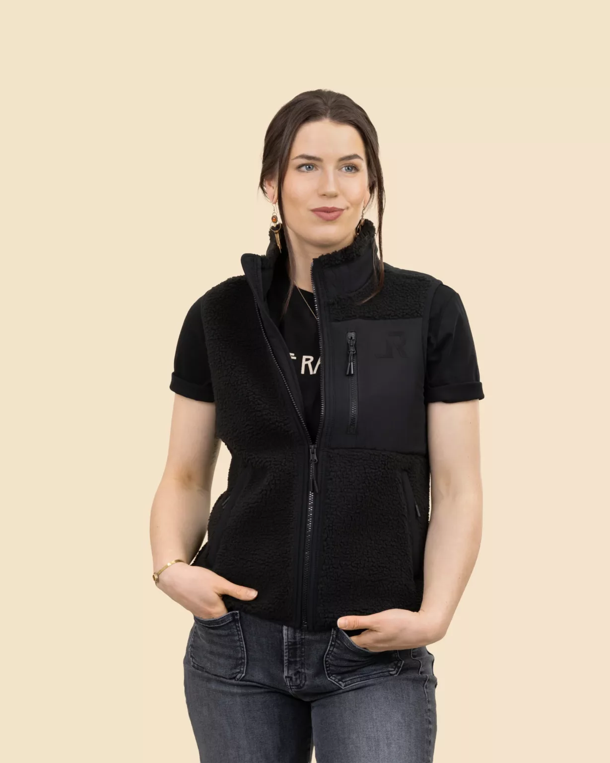 Woman wearing the black sherpa vest by LavendersRanch (LR) made from recycled polyester with vinyl LR logo, western country style.