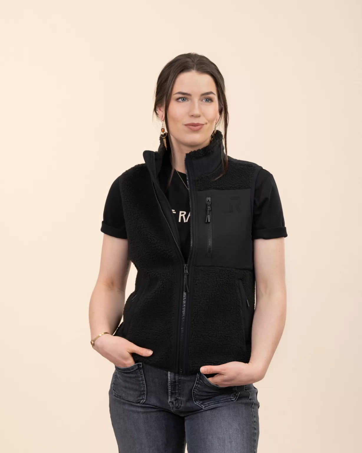 Woman wearing the black sherpa vest by LavendersRanch (LR) made from recycled polyester with vinyl LR logo, western country style.