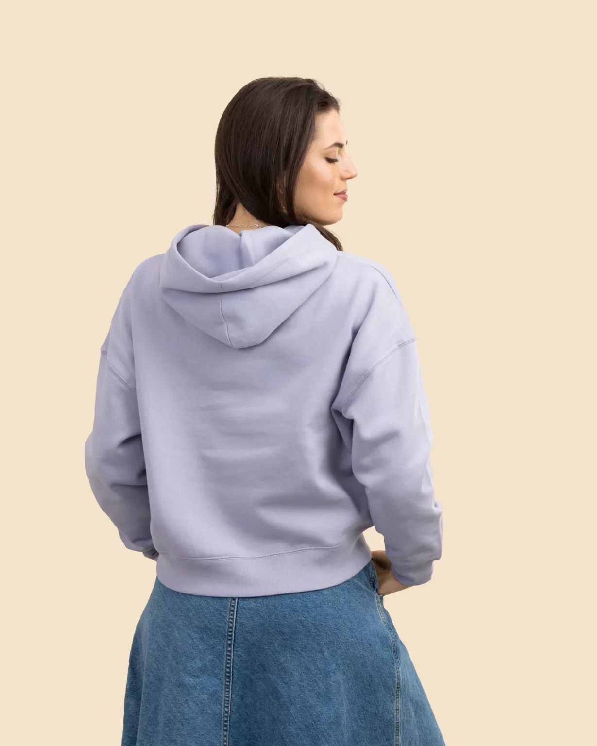 Woman seen from the back wearing a lavender cropped hoodie by LavendersRanch (LR), styled with a denim skirt, showcasing sustainable western country fashion and relaxed fit.